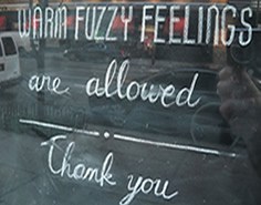 A chalkboard with the text "WARM FUZZY FEELINGS are allowed Thank you".
