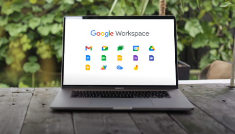 A laptop on a table displaying Google Workspace and various Google related icons