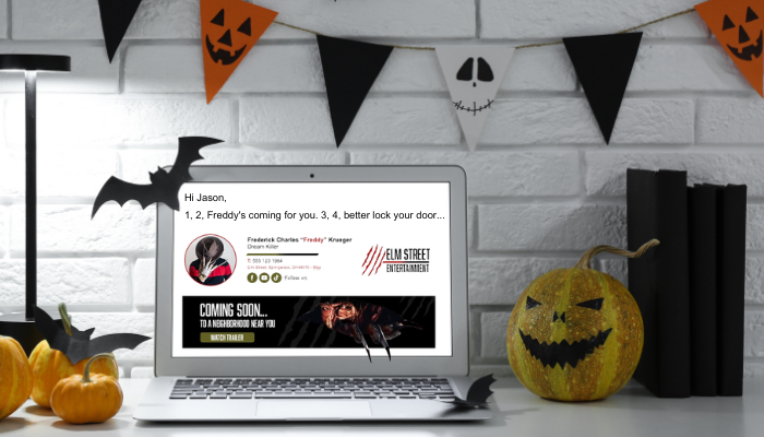 A laptop featuring a Halloween-themed email signature of Freddy Krueger, complete with a spooky banner, set in a Halloween-decorated office.