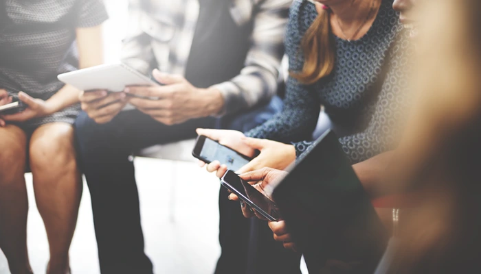 A group of people sitting in a circle on their mobile devices